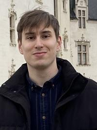 blonde hair smiling student with black coat