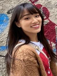 black hair student smiling in the brown sweater