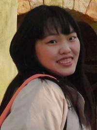 black hair student smiling in beige coat