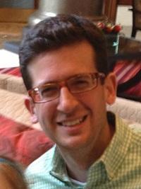 tim joseph professor classics, headshot of a man smiling at the camera with dark short hair and glasses