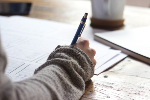 Stock photo of a hand writing on paper.